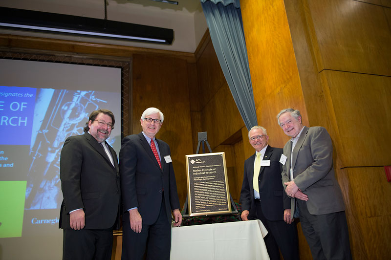 Click to enlarge photo of plaque with Mark Kamlet, Fred Gilman, Tom Barton and Guy Berry